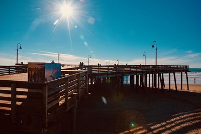 Pier over street against blue sky