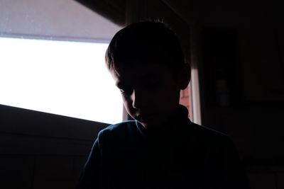 Close-up of boy looking through window
