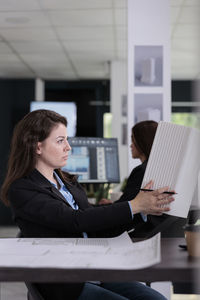 Businesswoman using laptop while sitting on table