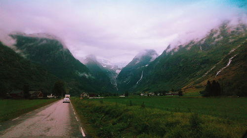 Country road against mountains in foggy weather