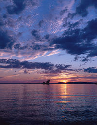 Scenic view of sea against dramatic sky during sunset