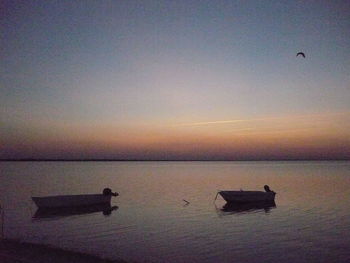 Silhouette boat in sea against sky during sunset