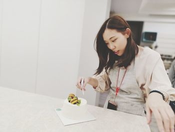 Young woman looking down while standing on table