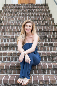 Portrait of smiling young woman sitting on steps