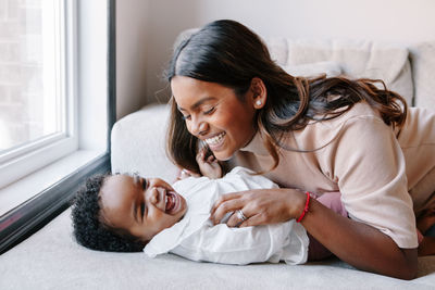 Happy smiling laughing indian mother playing with black baby girl daughter. family mixed race people 