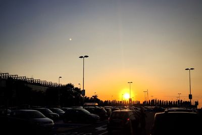 Cars on road against sky during sunset