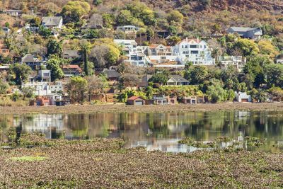 Houses by lake and buildings in town