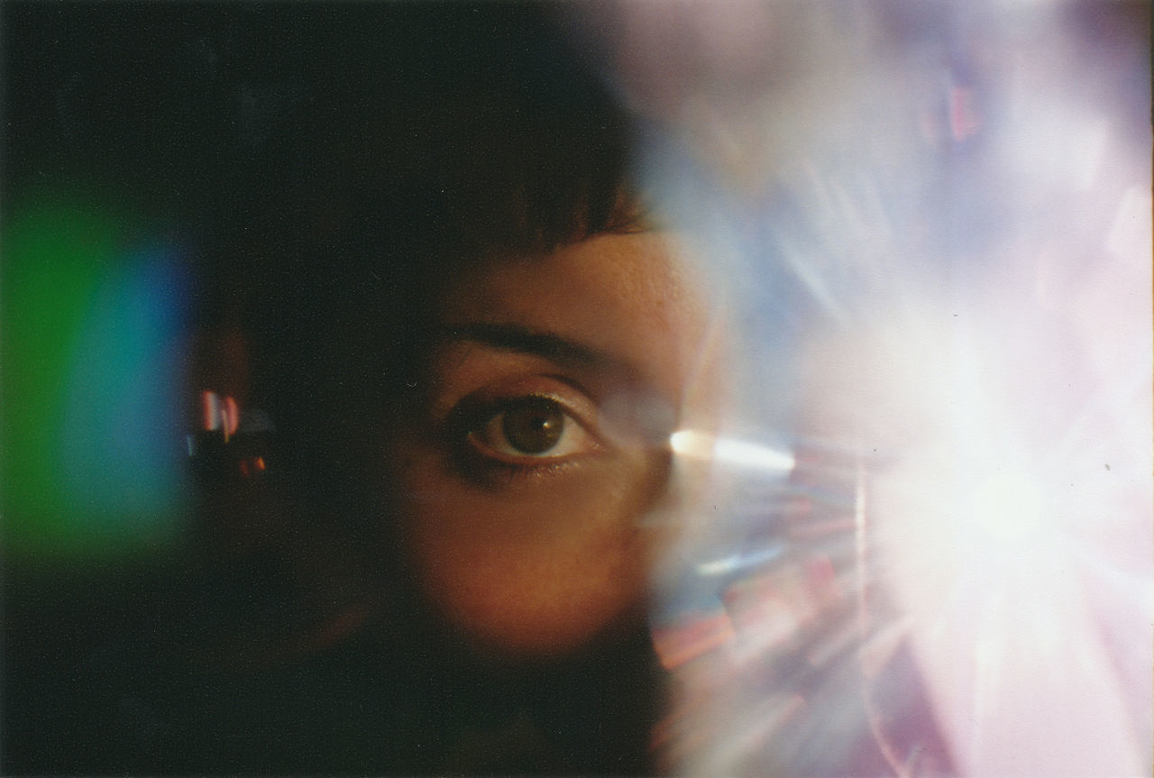 CLOSE-UP PORTRAIT OF YOUNG MAN PHOTOGRAPHING ILLUMINATED