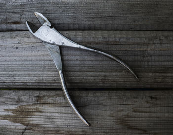 Directly above shot of dental pliers on wooden table