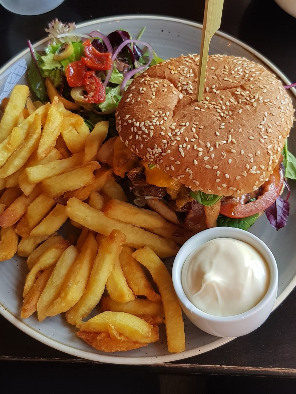 HIGH ANGLE VIEW OF BURGER AND VEGETABLES ON TABLE