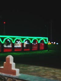 Illuminated bridge over river in city at night