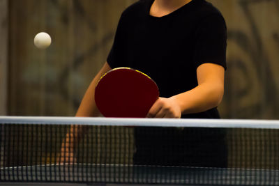 Midsection of man playing table tennis