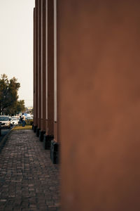 Footpath by street in city against sky