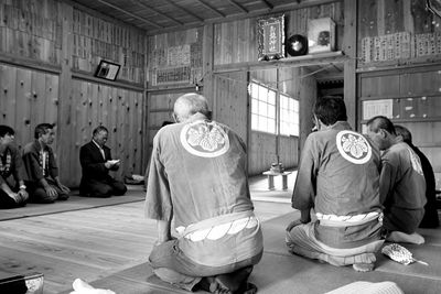 Rear view of people sitting outside building