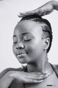 Close-up portrait of young woman against white background