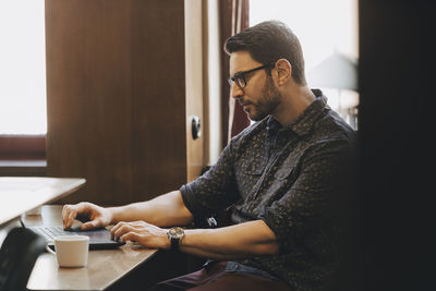 Mid adult businessman using laptop at desk in new office