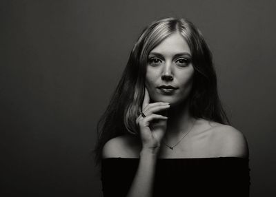 Portrait of beautiful young woman against black background