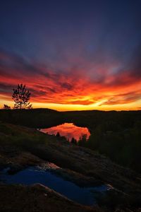 Scenic view of silhouette landscape against orange sky