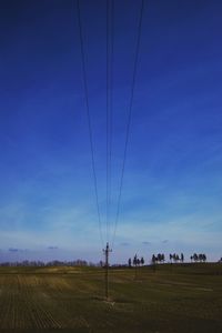 Electricity pylon on field against cloudy sky