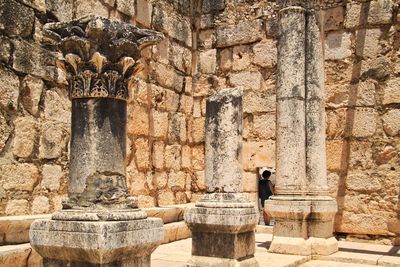 Rear view of man standing against stone wall