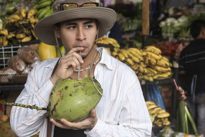 Latin man drinking coconut water