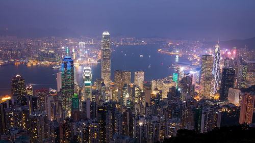 Illuminated cityscape against sky at night