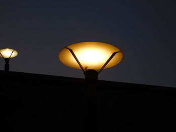 Low angle view of lamp lit up at night