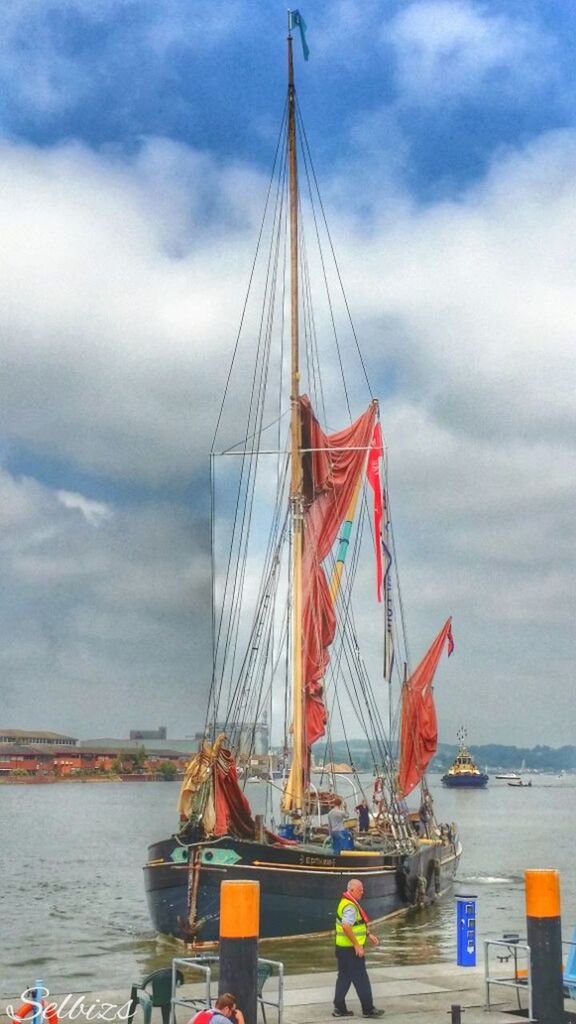 sky, nautical vessel, transportation, water, cloud - sky, sea, mast, boat, mode of transport, sailboat, cloudy, flag, cloud, sailing, travel, suspension bridge, patriotism, day, waterfront, outdoors