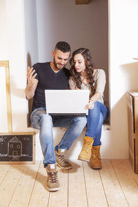 Portrait of smiling woman using laptop at home