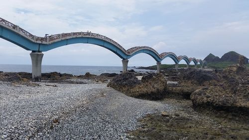 Arch bridge over sea against sky