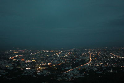 High angle view of illuminated buildings against sky at night