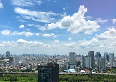 Aerial view of buildings in city against sky