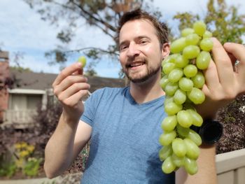 Portrait of smiling young man holding fruits