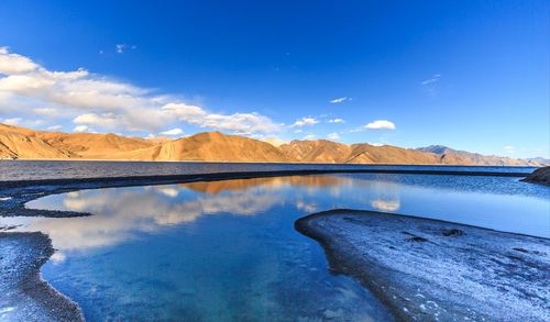 Scenic view of lake against blue sky during winter