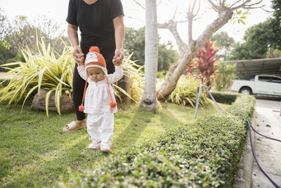 Full length of boy standing by plants