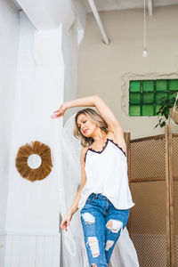 Full length of woman standing against white wall