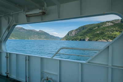 On a ferry crossing fjord. norway. view from hull opening at water and coastline with mountains. 