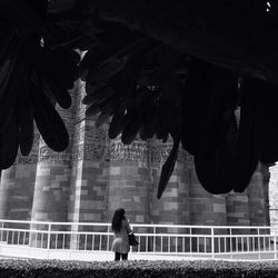 Woman standing by qutub minar on sunny day