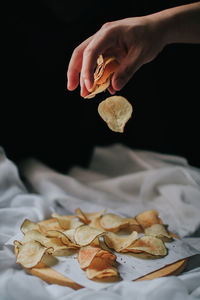 Close-up of hand holding leaf on table