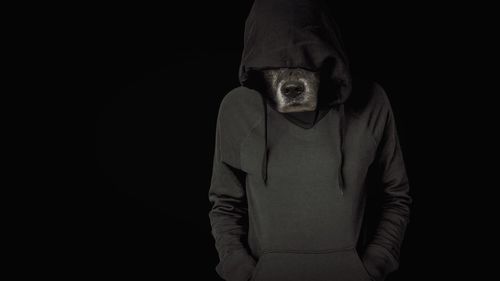 Man standing against black background