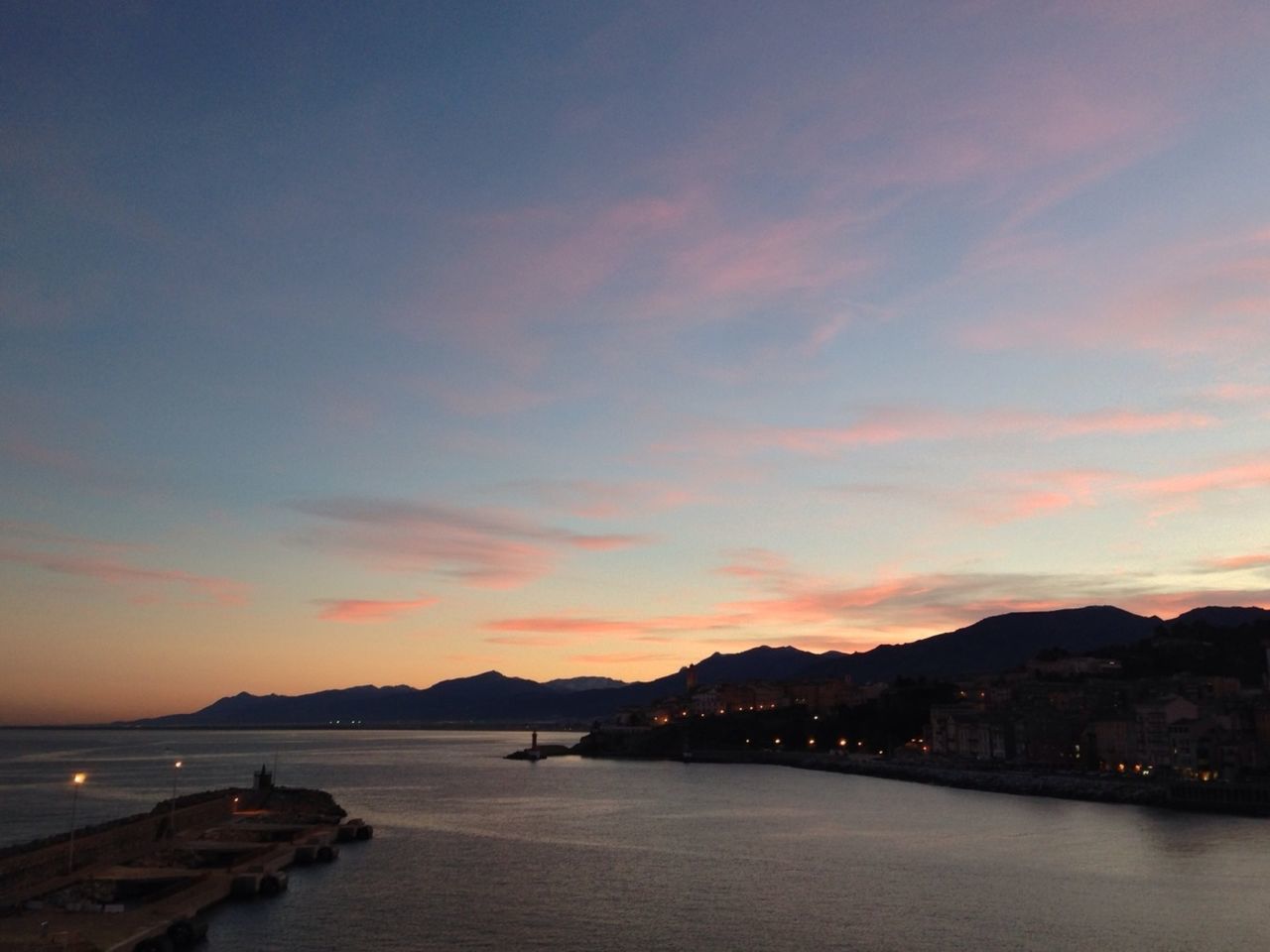 water, sunset, mountain, sky, scenics, waterfront, tranquil scene, beauty in nature, sea, tranquility, mountain range, nature, cloud - sky, idyllic, orange color, silhouette, river, nautical vessel, cloud, transportation