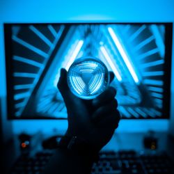 Close-up of hand holding illuminated light on ceiling