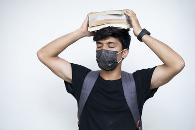 Portrait of young man standing against white background