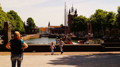 People on shore against sky