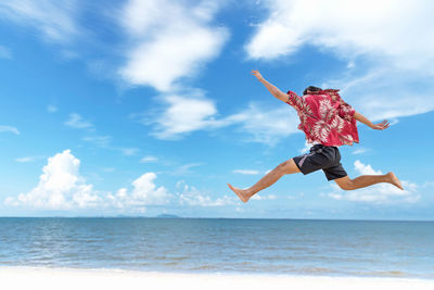 Low angle view of person jumping over sea against sky