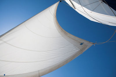 Cropped image of sailboat canvas against clear blue sky