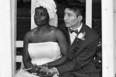 Well dressed bride and groom sitting outdoors