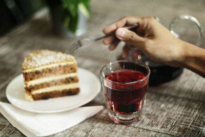 Close-up of hand with drink on table