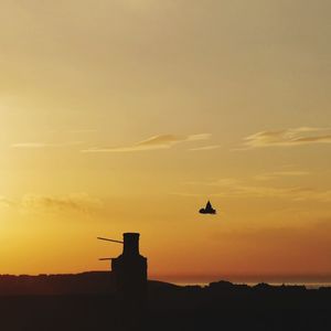 Silhouette of building against sky at sunset