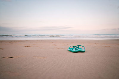 High angle view of flip-flops on beach against sea